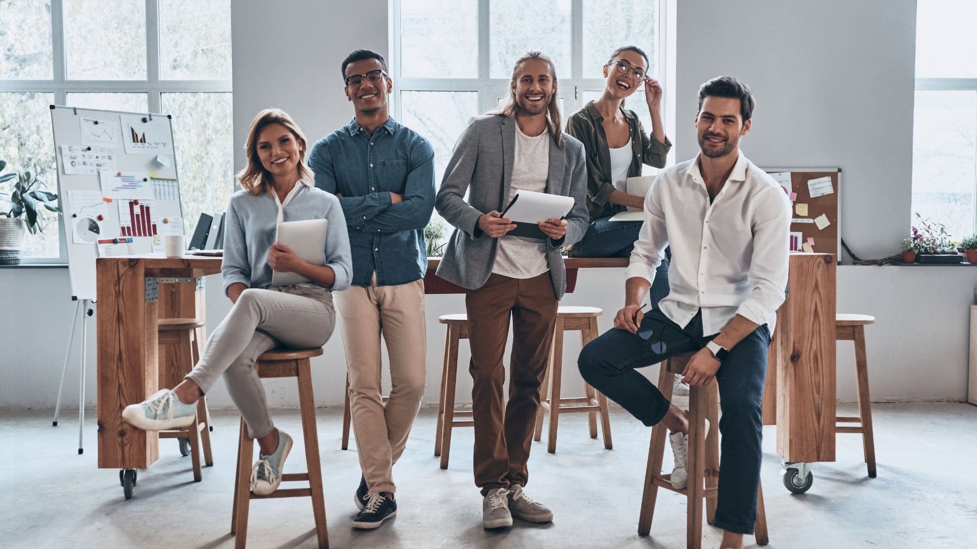 5 young people at work looking at the camera