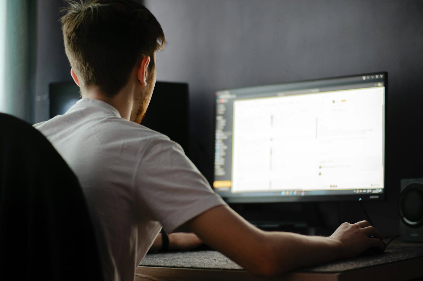 A man sitting in front of a computer monitor