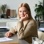 A businesswoman poses at her desk.